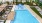 aerial view of pool deck with shaded seating areas and sun loungers