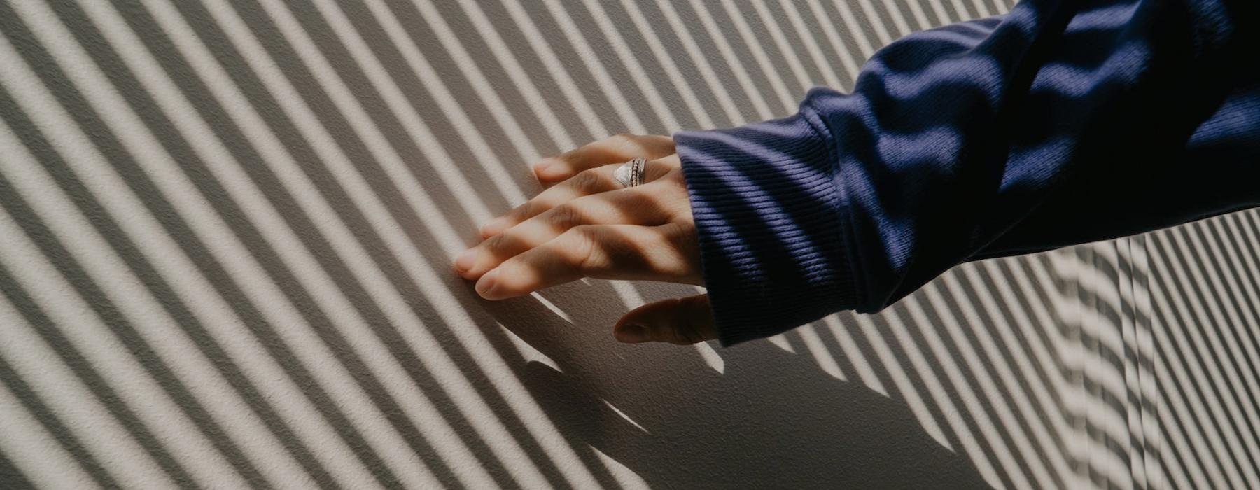 a person's hand on a striped surface